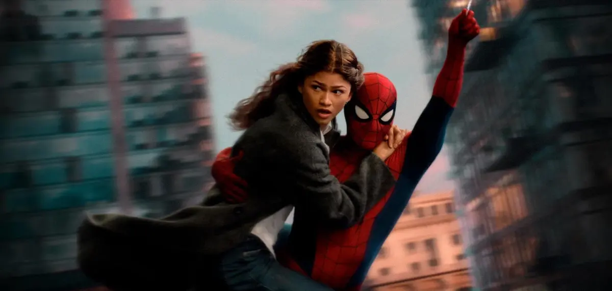 MJ held by Spider-Man as they swing between buildings