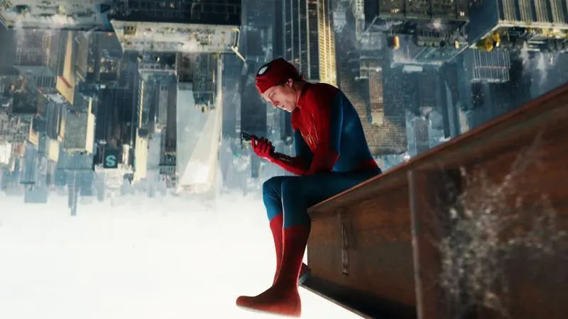 Spider-Man sitting upside down holding his phone